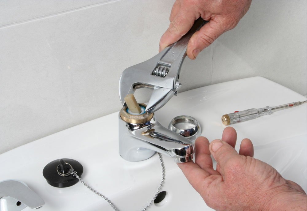 Plumber fixing faucet with wrench tool