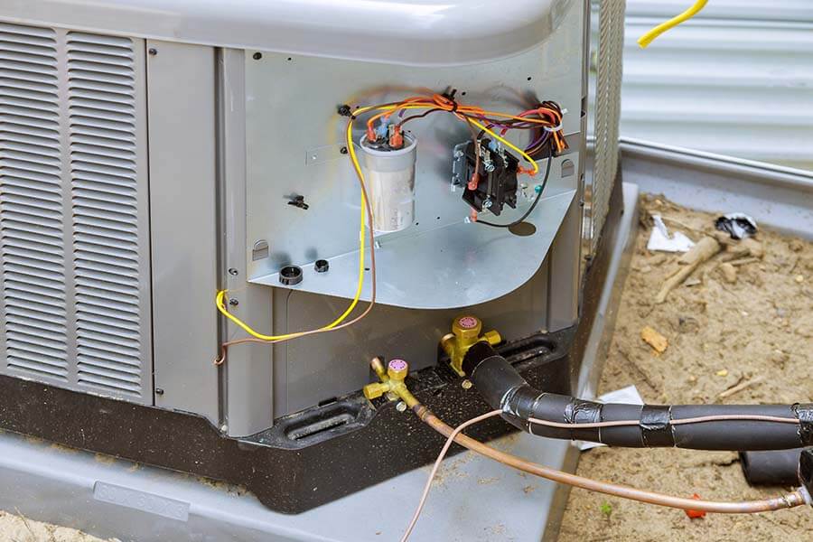 Open AC unit showing wires and capacitor